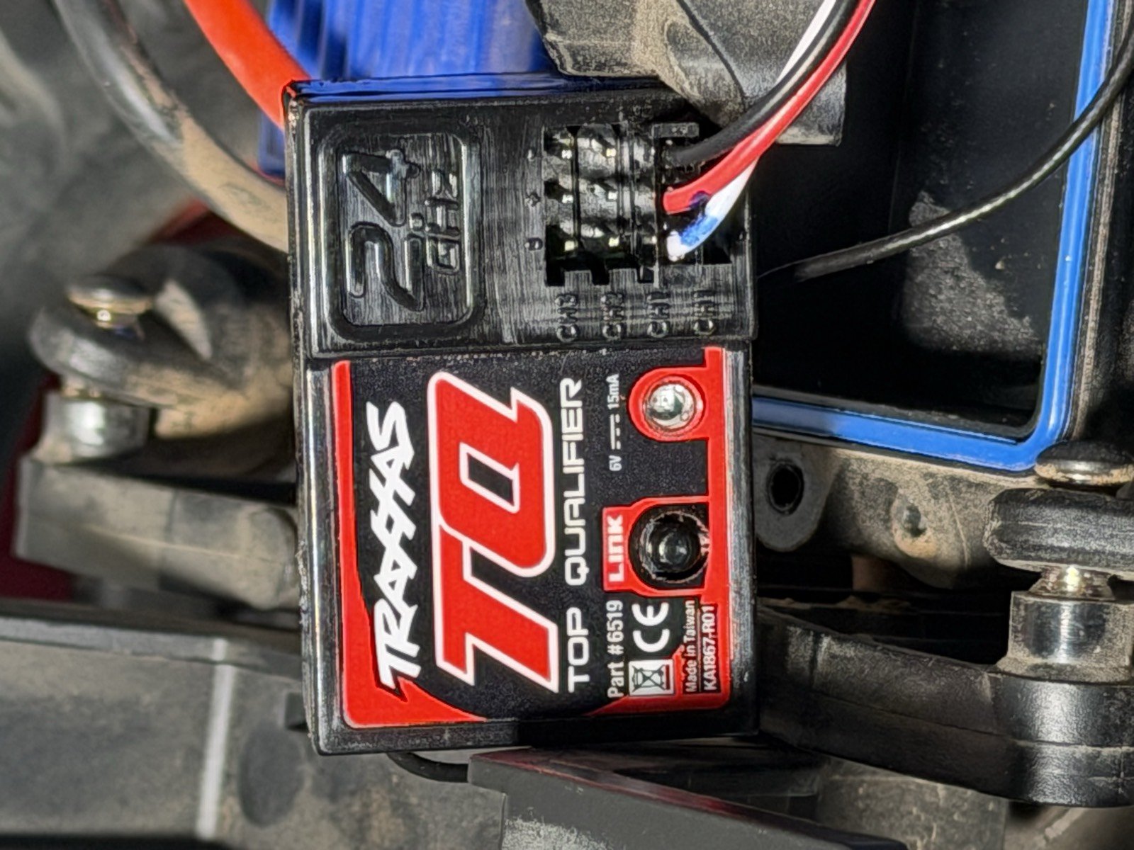 Traxxas TQ 6519 receiver mounted in the truck, showing its row of ports and a label reading 6V 15mA